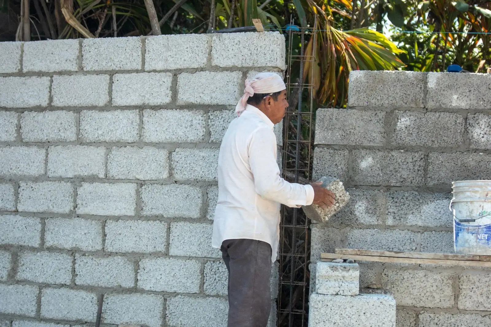 Mason laying a concrete block wall course by course