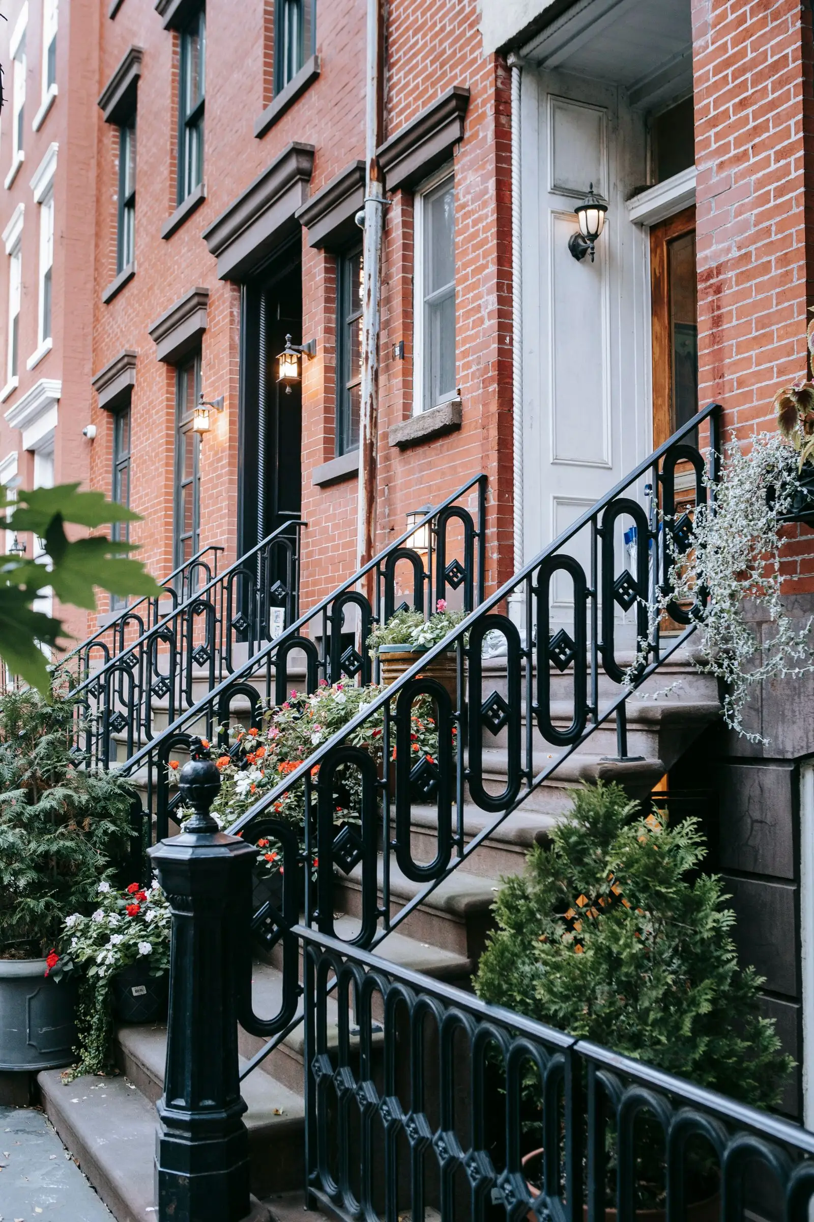 Stone front steps with a metal handrail against a brick house