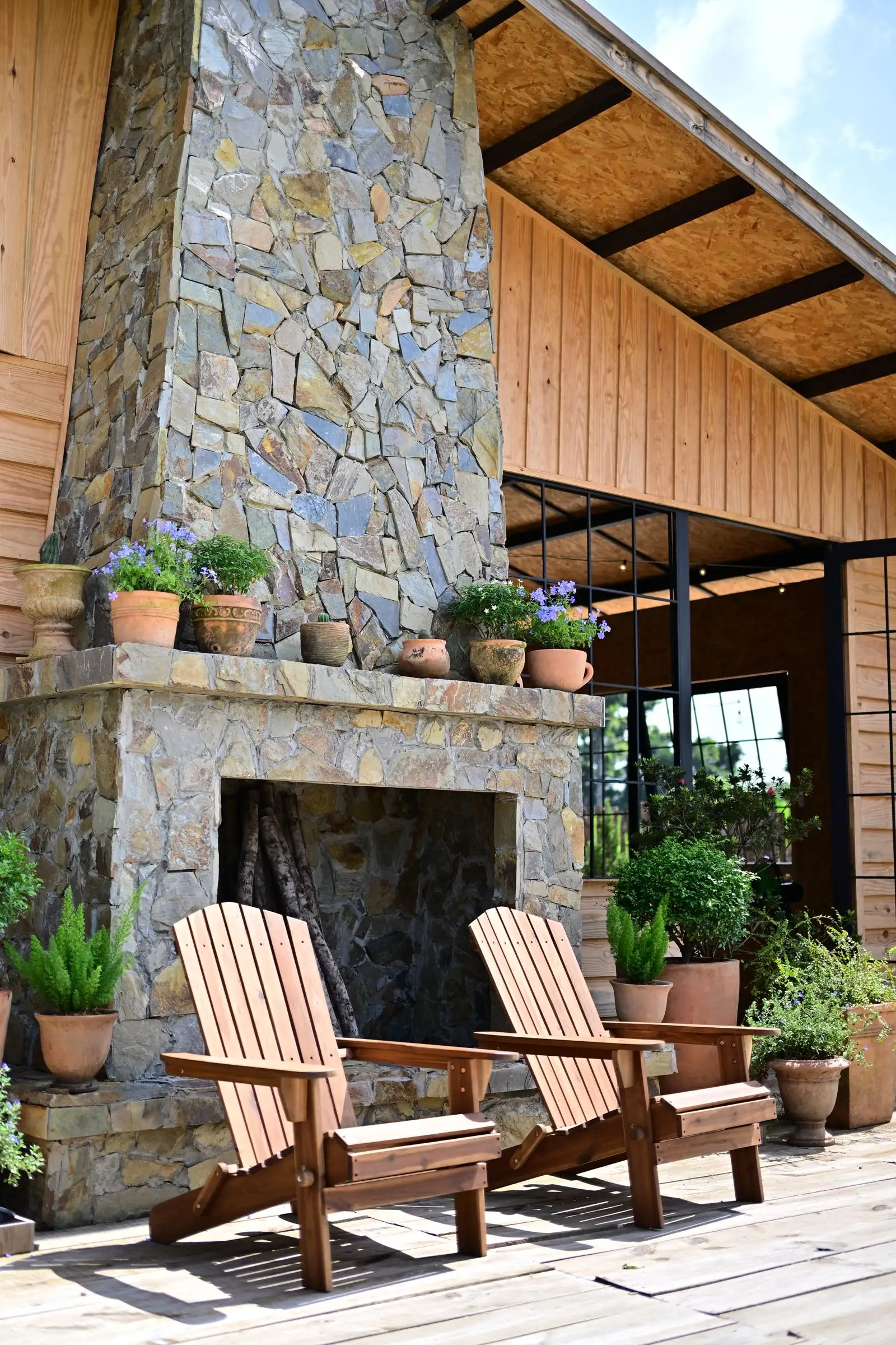 Built stone outdoor fireplace and chimney on a planted patio