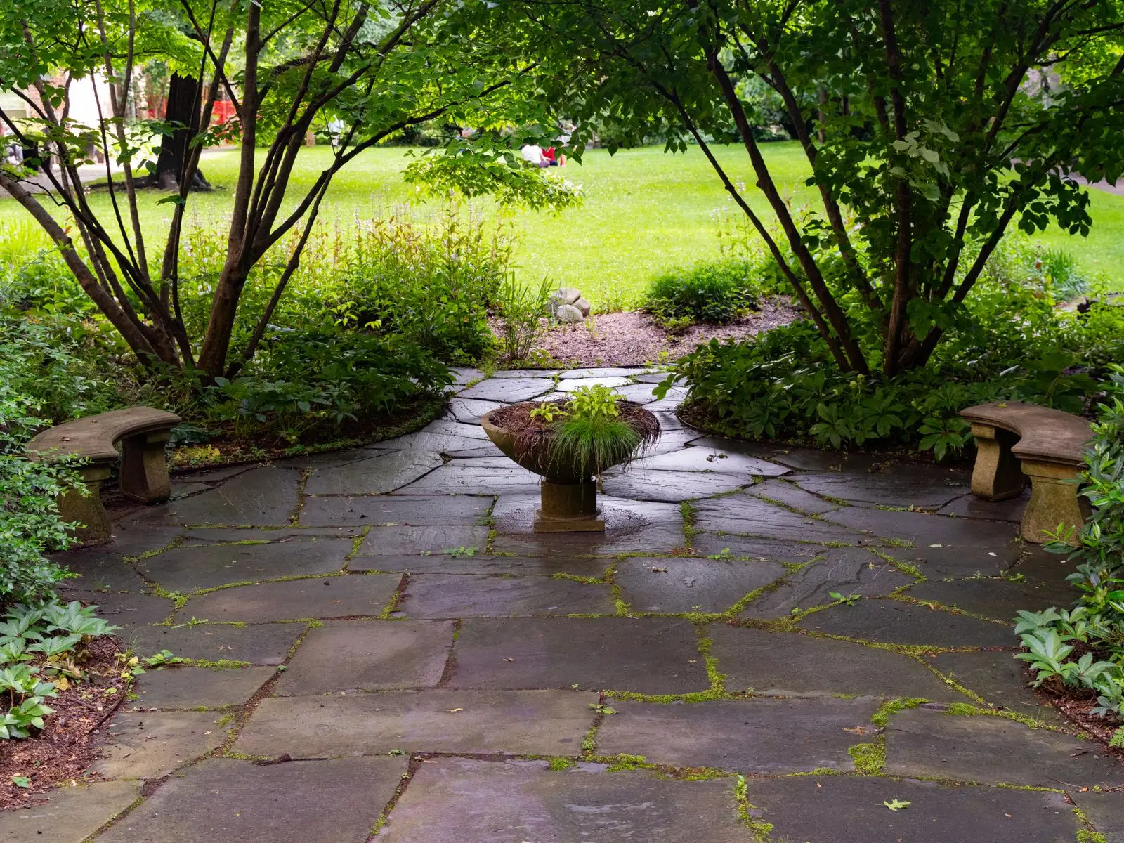 Wide flagstone and concrete patio set into a planted garden