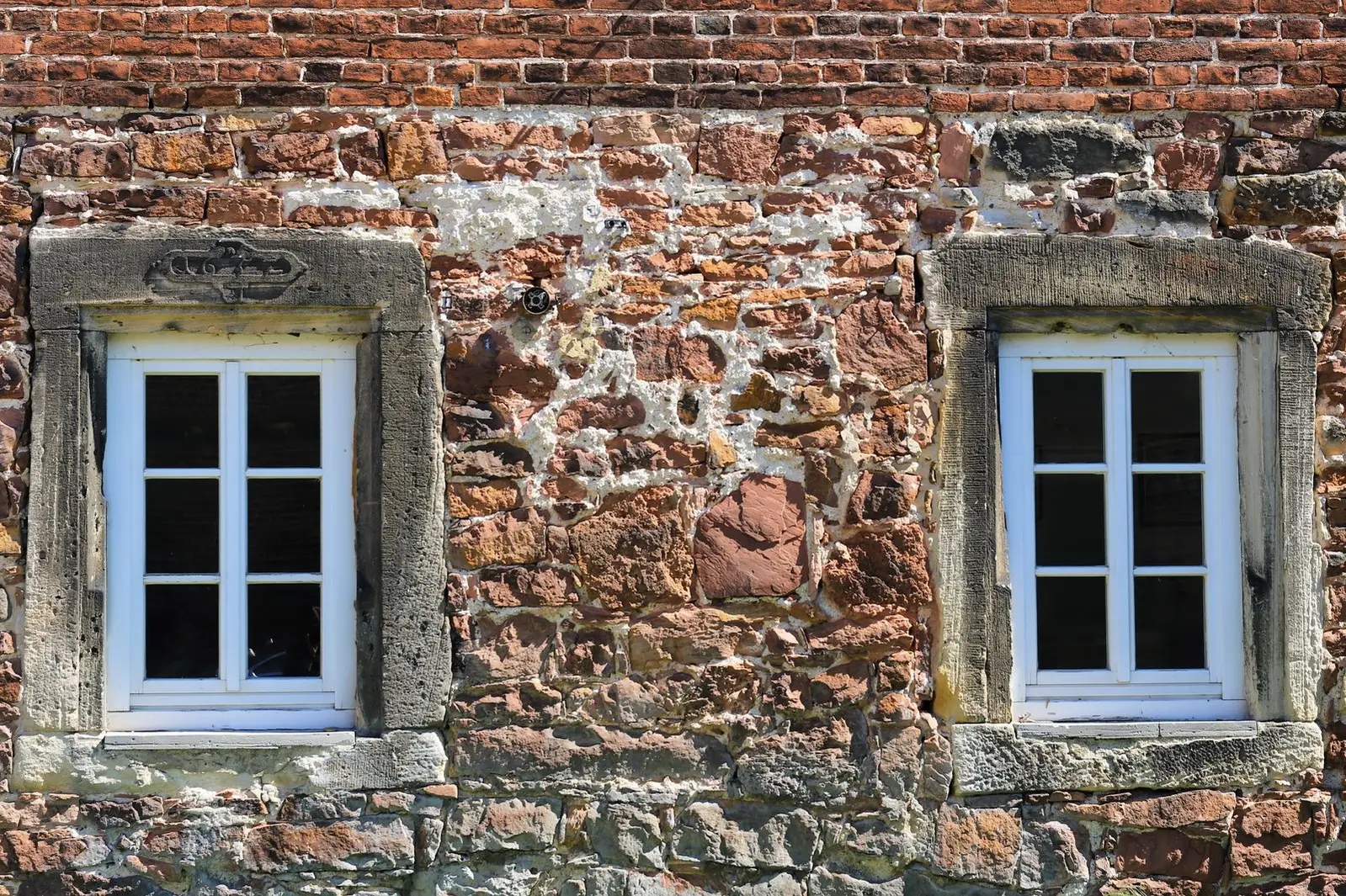 Fitted natural stone veneer on a house facade around two windows
